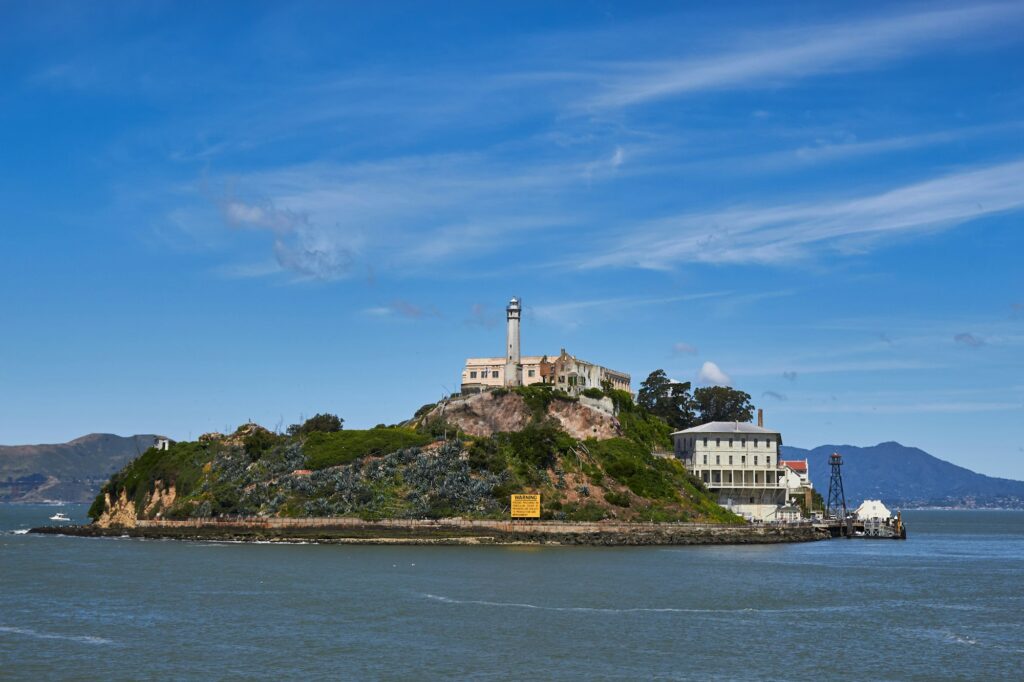 Alcatraz Island and its lighthouse under a blue sky in San Francisco Bay